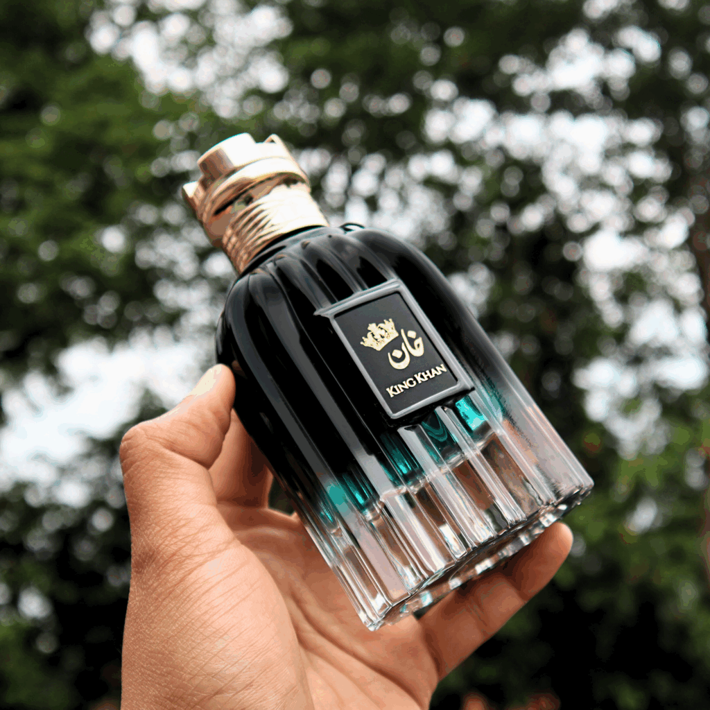Banner image of someone holding 'Best Perfumes For Winter Season: King Khan by French Arabian 100ml Eau de Parfum for Men' forest in background